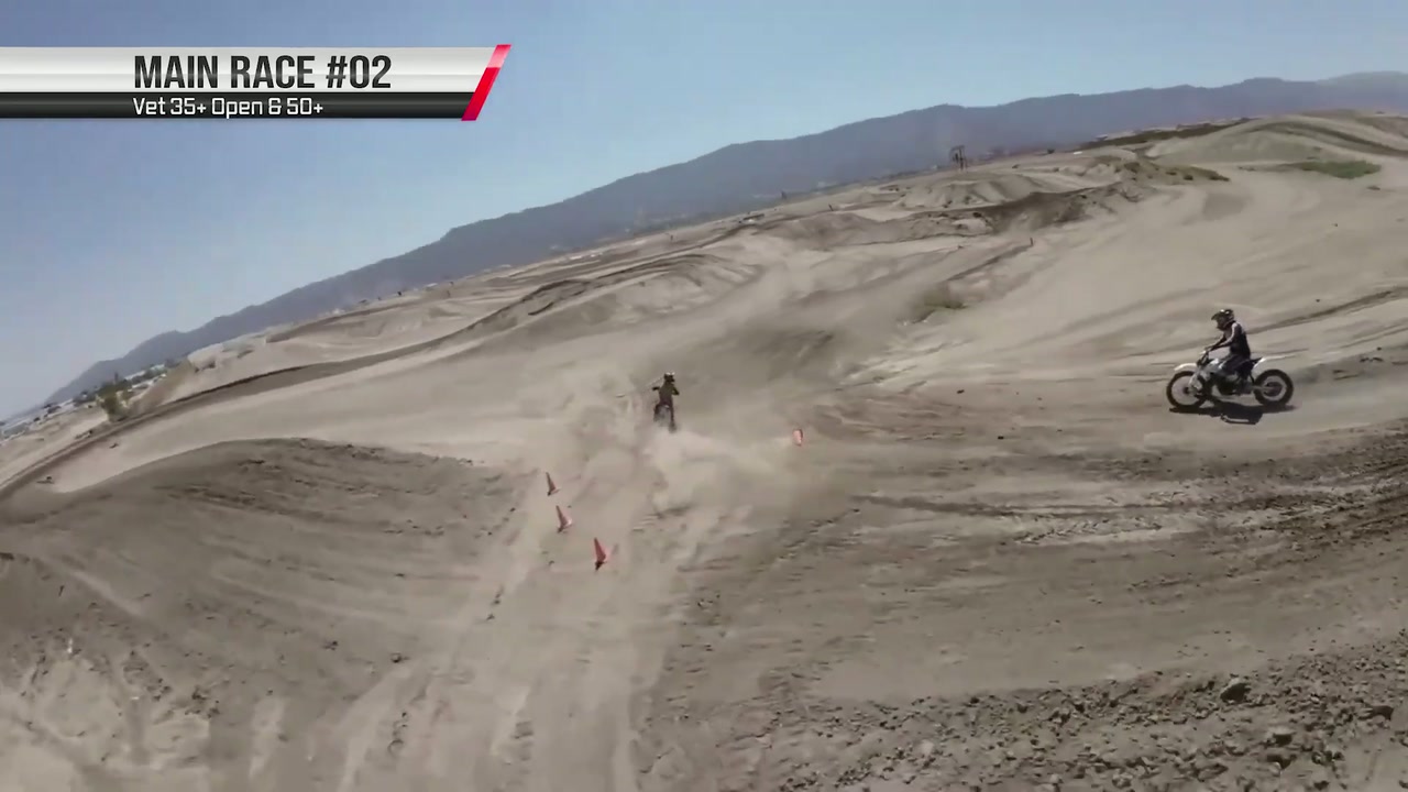 Two riders working across an open sweep of track, framed by the Race Day Aerials drone feed as it went out on an eMoto Racing live broadcast.